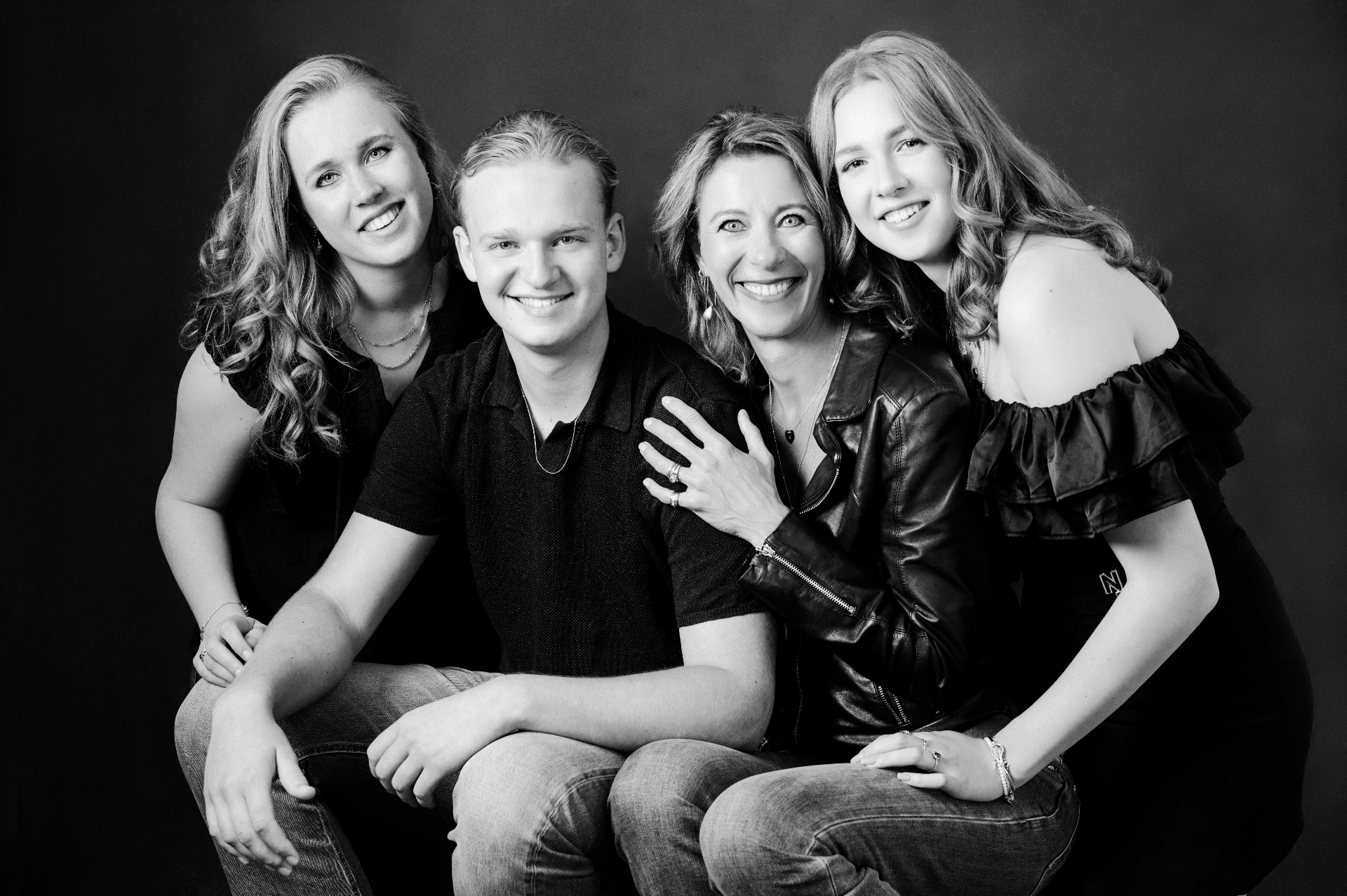 A family sitting close together in soft, warm light.