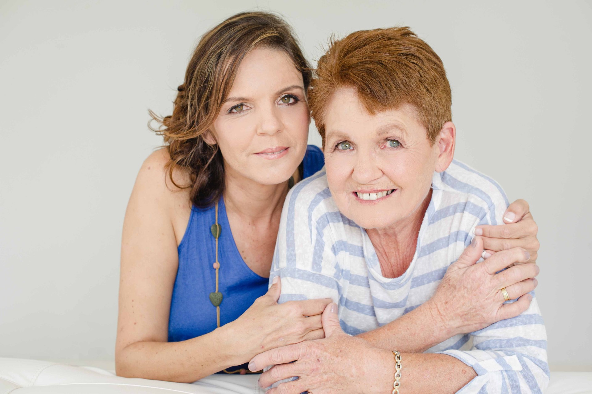 A grown daughter resting close to her mother, warm and tender.